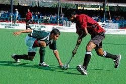 HAL and SAI teams trying to get possession of the ball at the State-level Super Division           Hockey League Championship in Madikeri on Saturday.  DH Photo