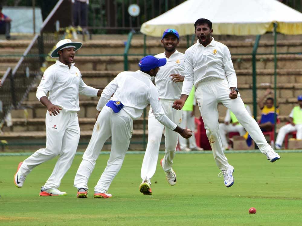 bright start: Karnataka's Shreyas Gopal (right) celebrates with team-mates after dismissing Assam's Wasiqur Rehman during their Ranji match at the SDNR Wadiyar Stadium in Mysuru on Saturday. DH photo/ Irshad Mahammad