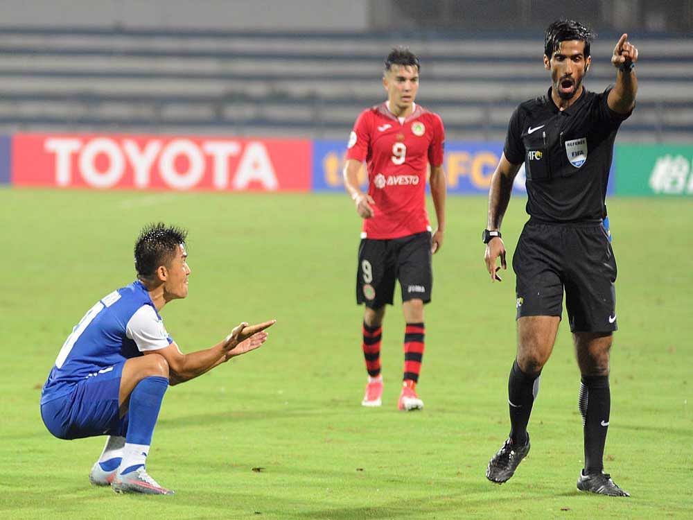 FALLING IN DEAF EARS: Bengaluru FC's Sunil Chhetri pleads with referee Khamis Al Marri to overturn a penalty decision =during their game against FC Istiklol on Wednesday. DH PHOTO/ SRIKANTA SHARMA R