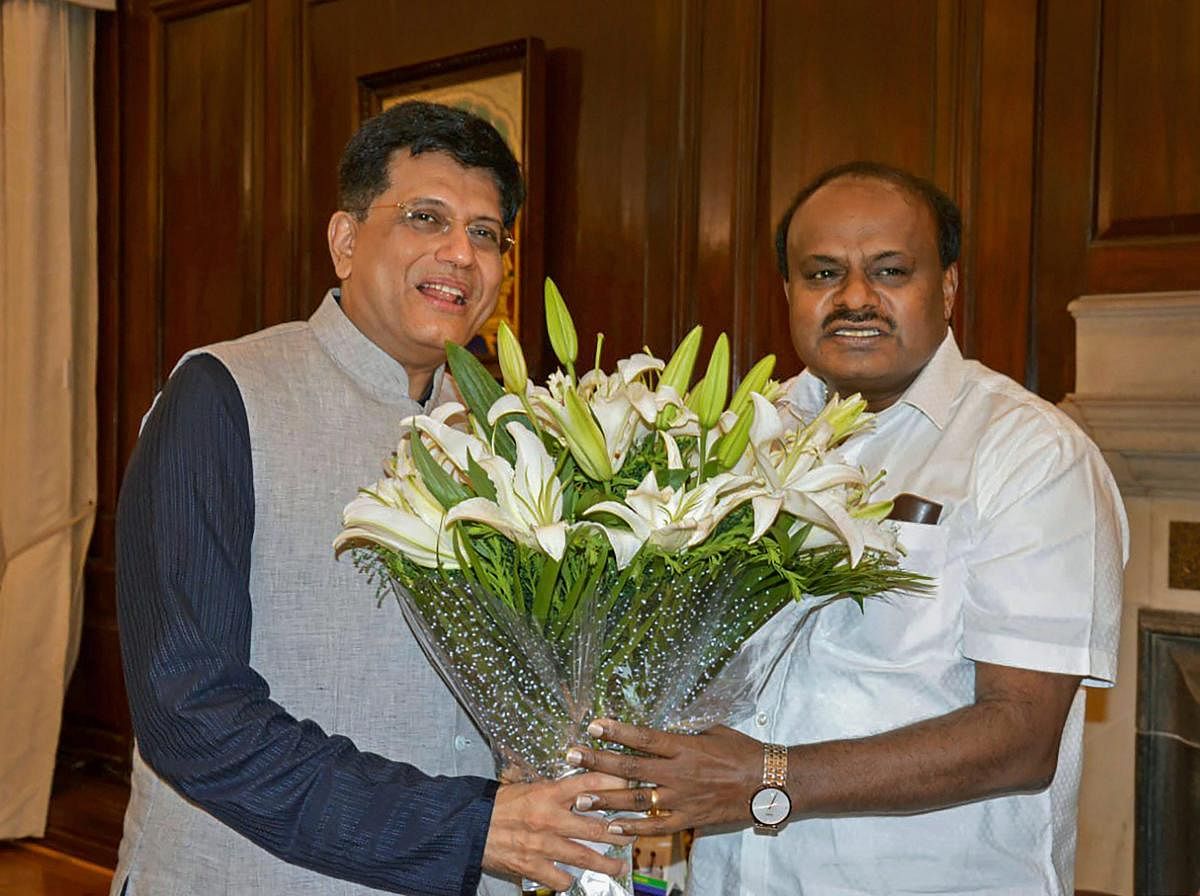 Union Coal Minister Piyush Goyal gives a bouquet to Karnataka Chief Minister HD Kumaraswamy before a meeting, in New Delhi on Wednesday, July 18, 2018. (PTI Photo) 