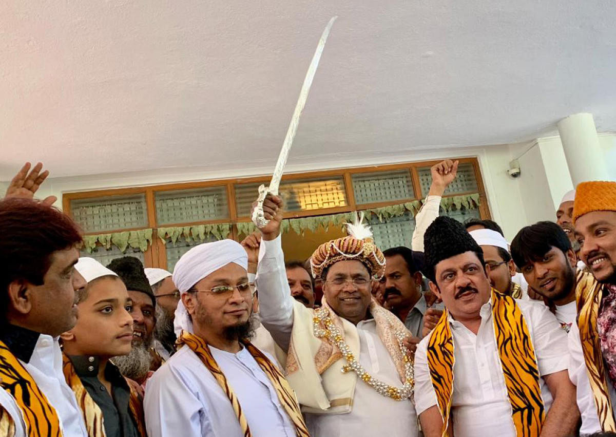 Minister zameer Ahamad Khan with his supporters felicitate former chief minister Siddaramaiah with Tipu turban and sword on the occassion of Tipu Jayanti in Bengaluru on Saturday.