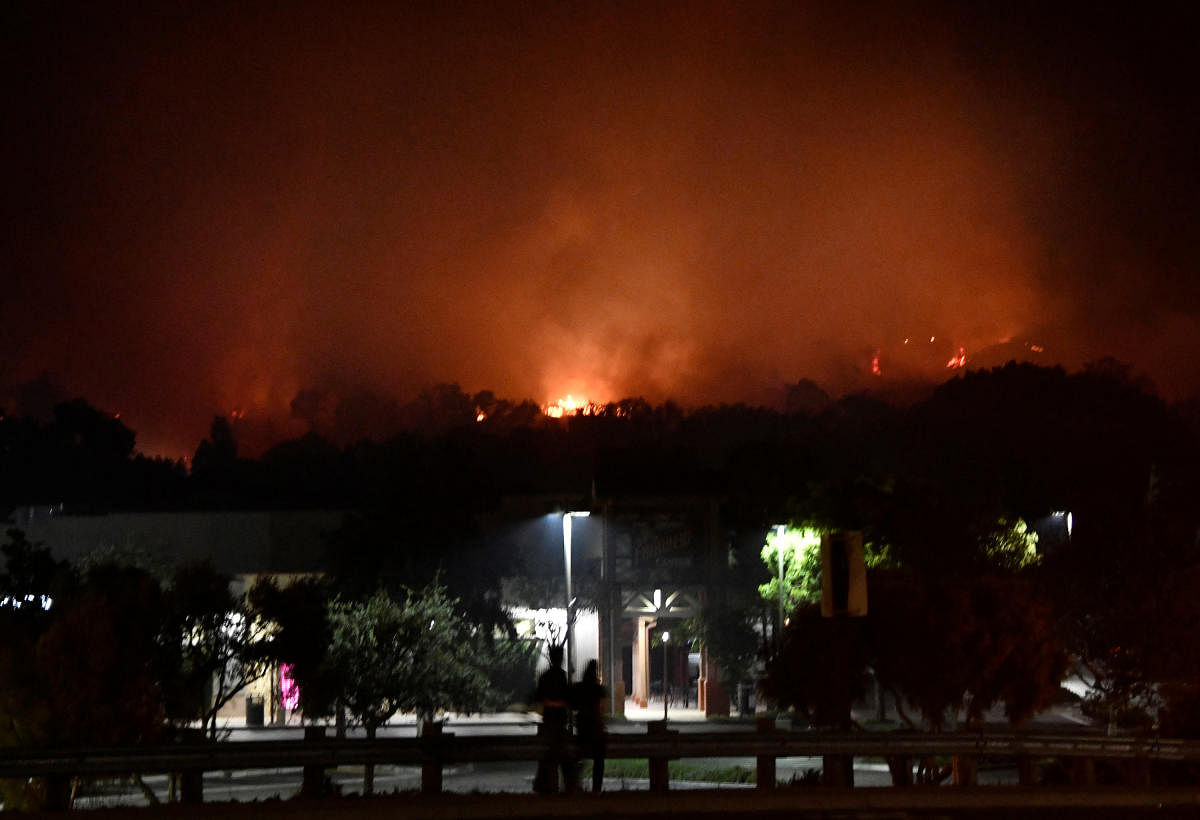 People watch as fast-moving wildfire, that destroyed homes driven by strong wind and high temperatures forcing thousands of residents to evacuate, burns in Goleta, California, U.S., early July 7, 2018. Reuters