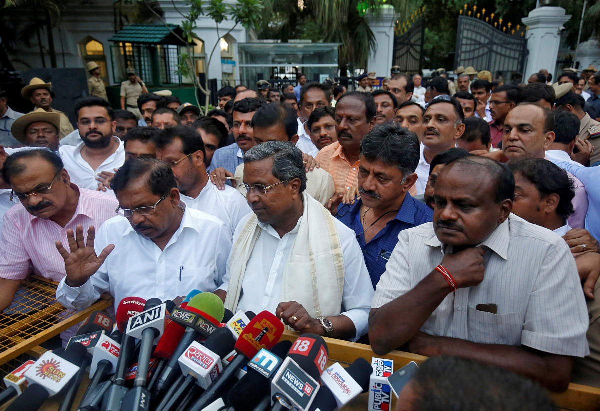 Outgoing Chief Minister of the southern state of Karnataka Siddaramaiah (C) and Janata Dal (Secular) leader H D Kumaraswamy (R) speak with the media outside the governor's house in Bengaluru, India, May 15, 2018. REUTERS