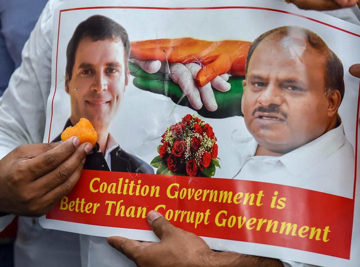 A poster of Congress president Rahul Gandhi and JD(S) chief HD Kumaraswamy after Karnataka Chief Minister BS Yeddyurappa announced his resignation, in New Delhi. PTI file photo