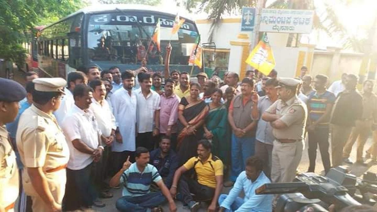 MP Pratap Simha, MLA L Nagendra and other BJP workers blocking KSRTC bus services in Mysuru on Monday. (DH Photo)