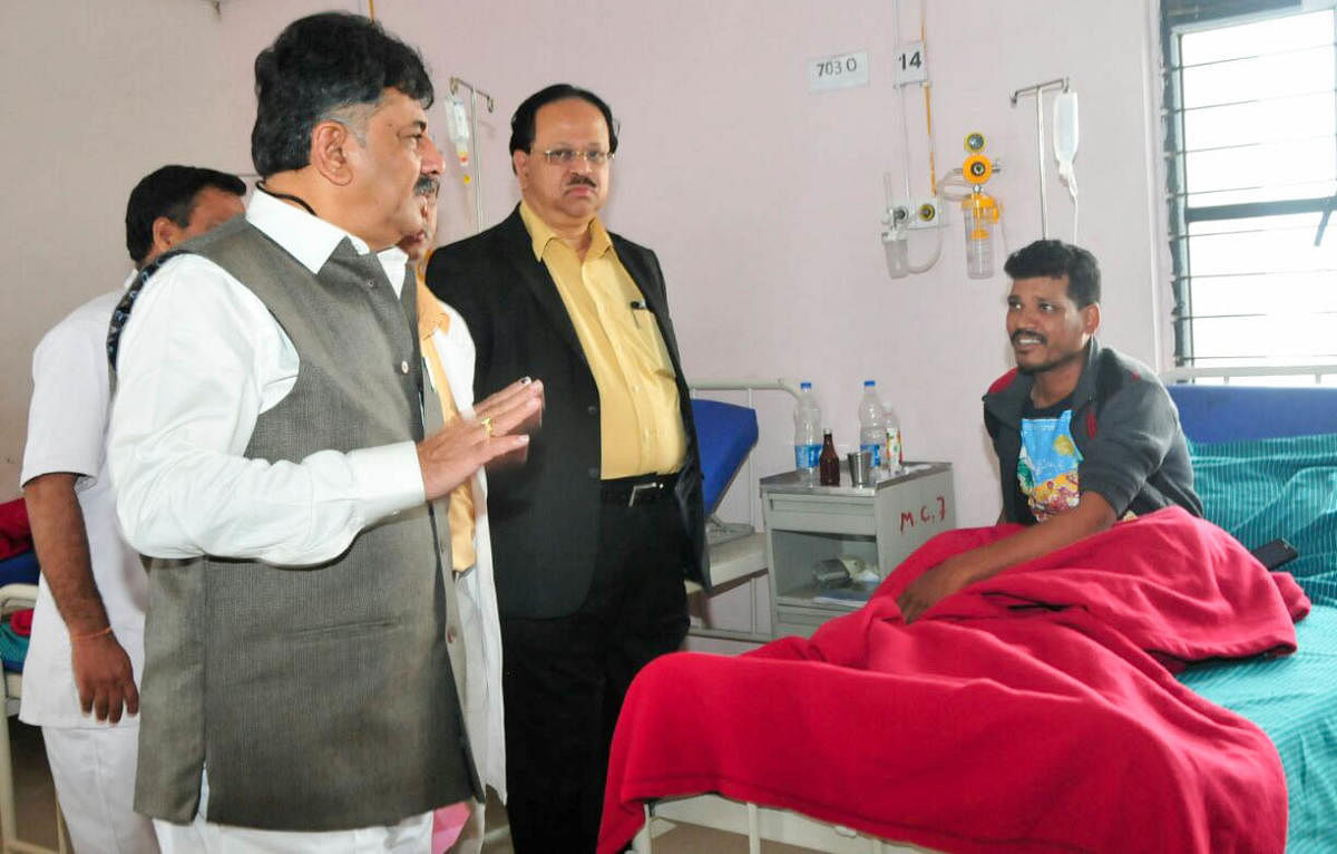 Medical education minister D K Shivakumar speaks to a patient during a surprise inspection of Victoria Hospital on Friday.