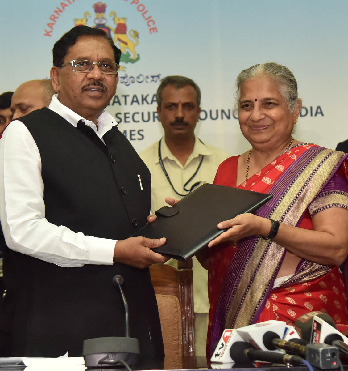 Infosys Foundation chairperson Sudha Murty and Deputy Chief Minister G Parameshwara exchange files after signing a Memorandum of Understanding for establishing the Centre for Cybercrime Investigation Training &amp; Research (CCITR) at the Vidhana Soudha i