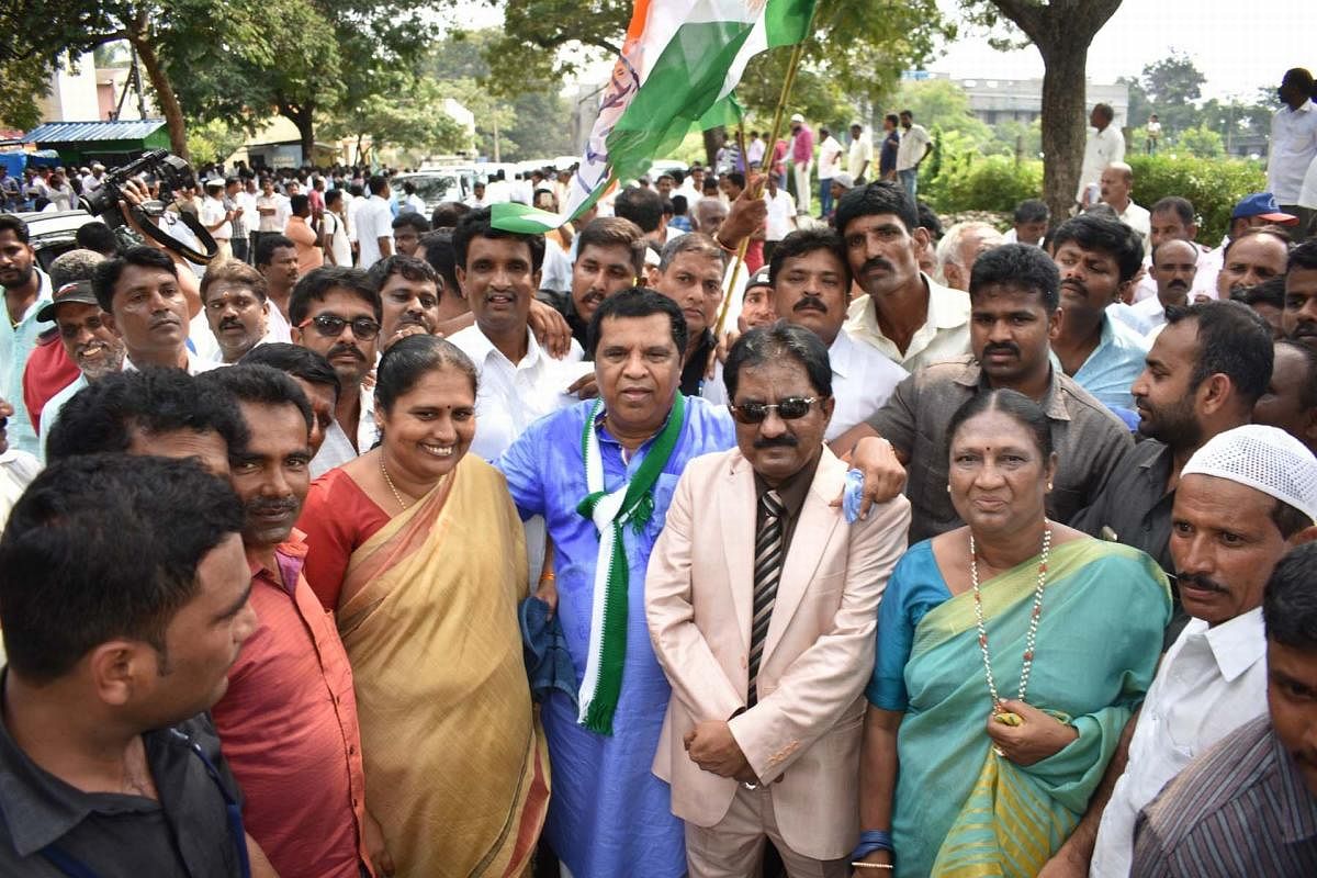 Solidarity march: JD(S)-Congress coalition candidate L R Shivaramegowda arrives in a procession to file his nomination papers for the Lok Sabha by-elections in Mandya on Monday.