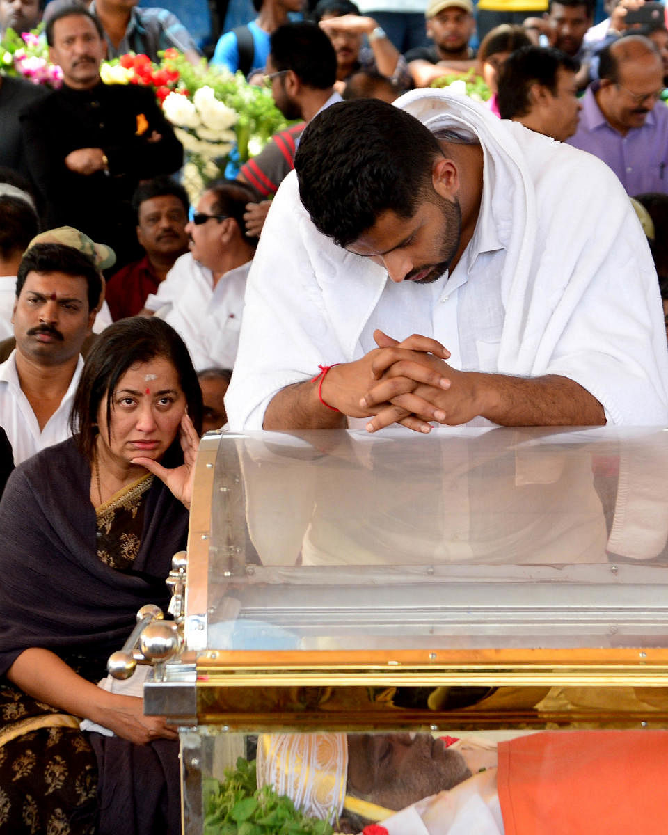 INCONSOLABLE: Sumalatha and Abhishek Gowda, wife and son of Ambareesh, mourn near his coffin at Shree Kanteerava stadium in Bengaluru on Sunday. DH photo/Ranju P