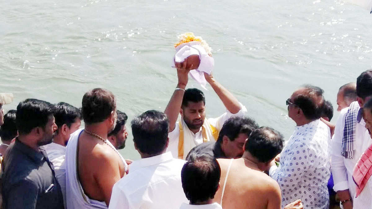 Abhishek Gowda, son of actor-politician M H Ambareesh, immerses the ashes of his father at Cauvery Sangama in Srirangapatna, Mandya district on Wednesday.