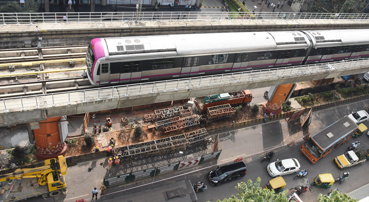 A Metro train moves slowly as work to fix pillar No. 155 is in progress near the Trinity Station in Bengaluru on Wednesday. DH Photo/Janardhan B K