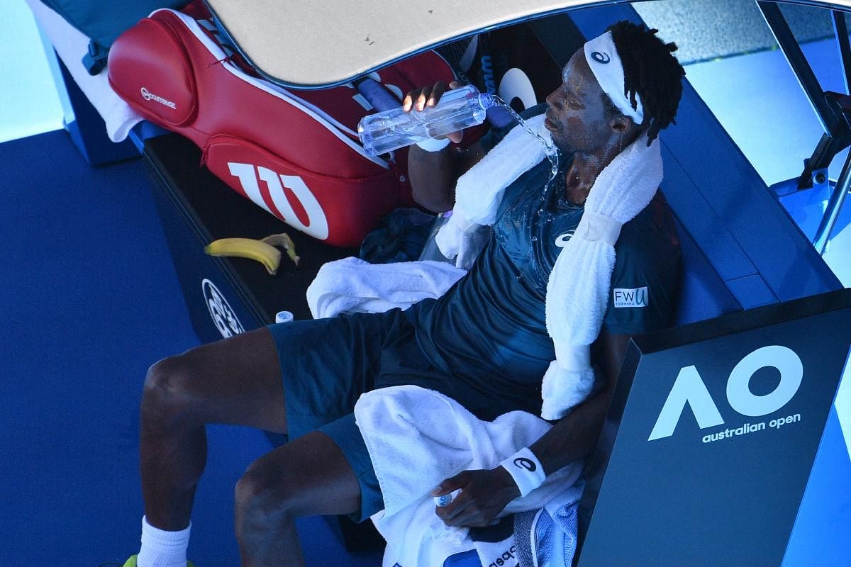 France's Gael Monfils pours water on himself to cool down from the heat during their men's singles match against Serbia's Novak Djokovic in last year's Australian Open. AFP
