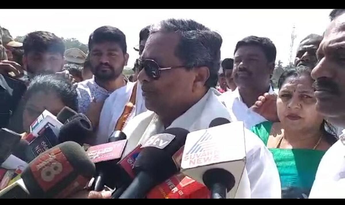Former chief minister and chairman of the Coalition Government Coordination Committee, Siddaramaiah, speaks to reporters at KLK helipad in Birur on Wednesday.