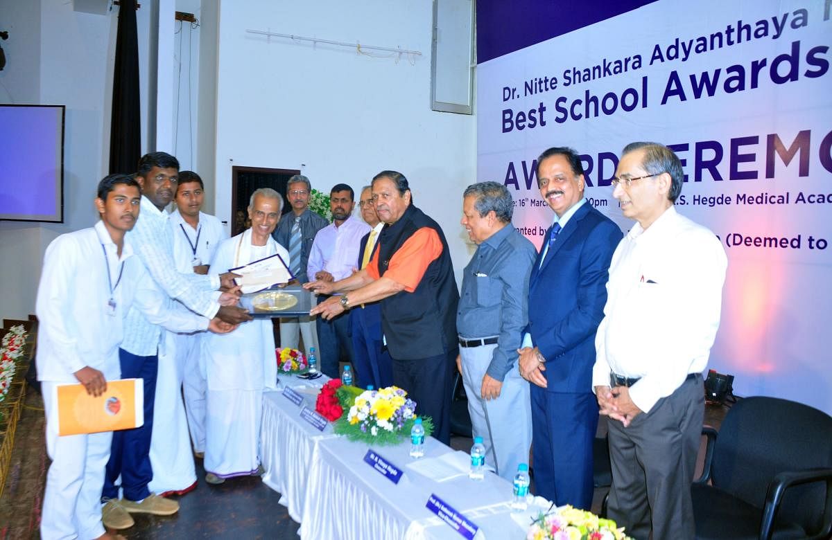 Former Lokayukta Justice N Santosh Hegde hands the Dr Nitte Shankara Adyanthaya Memorial Best School Award at a programme held at Deralakatte on Saturday.