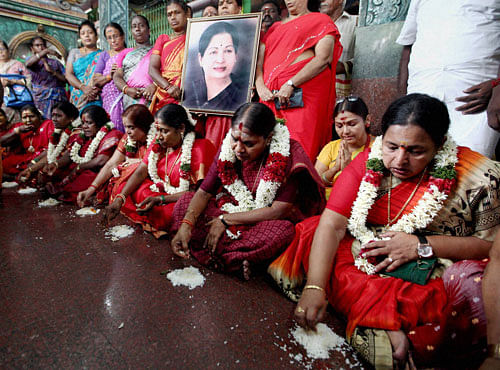 AIADMK women wing members eat off the floor as a prayer for the speedy recovery of party supremo and Chief Minister Jayalalithaa, at a temple in Chennai on Tuesday. PTI