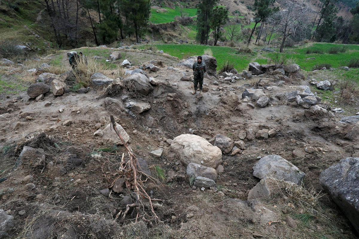 Pakistan's army soldier stands at the edge of a crater, after Indian military aircrafts struck on February 26, according to Pakistani officials, in Jaba village, near Balakot. Reuters photo