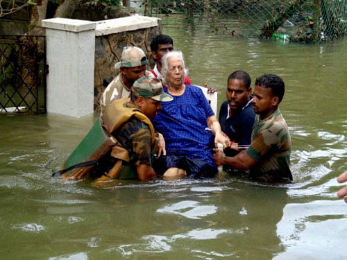 Army personnel carrying an elderly woman to safe place during their rescue operation in flood affected Chennai on Friday. PTI Photo