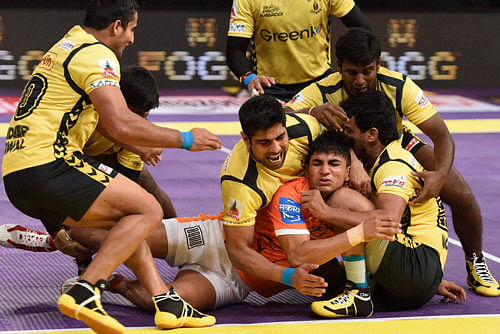 Players in action during a Pro Kabaddi League match between Puneri Paltans (Orange) and Telugu Titans(Yellow) in Mumbai on Saturday. PTI Photo