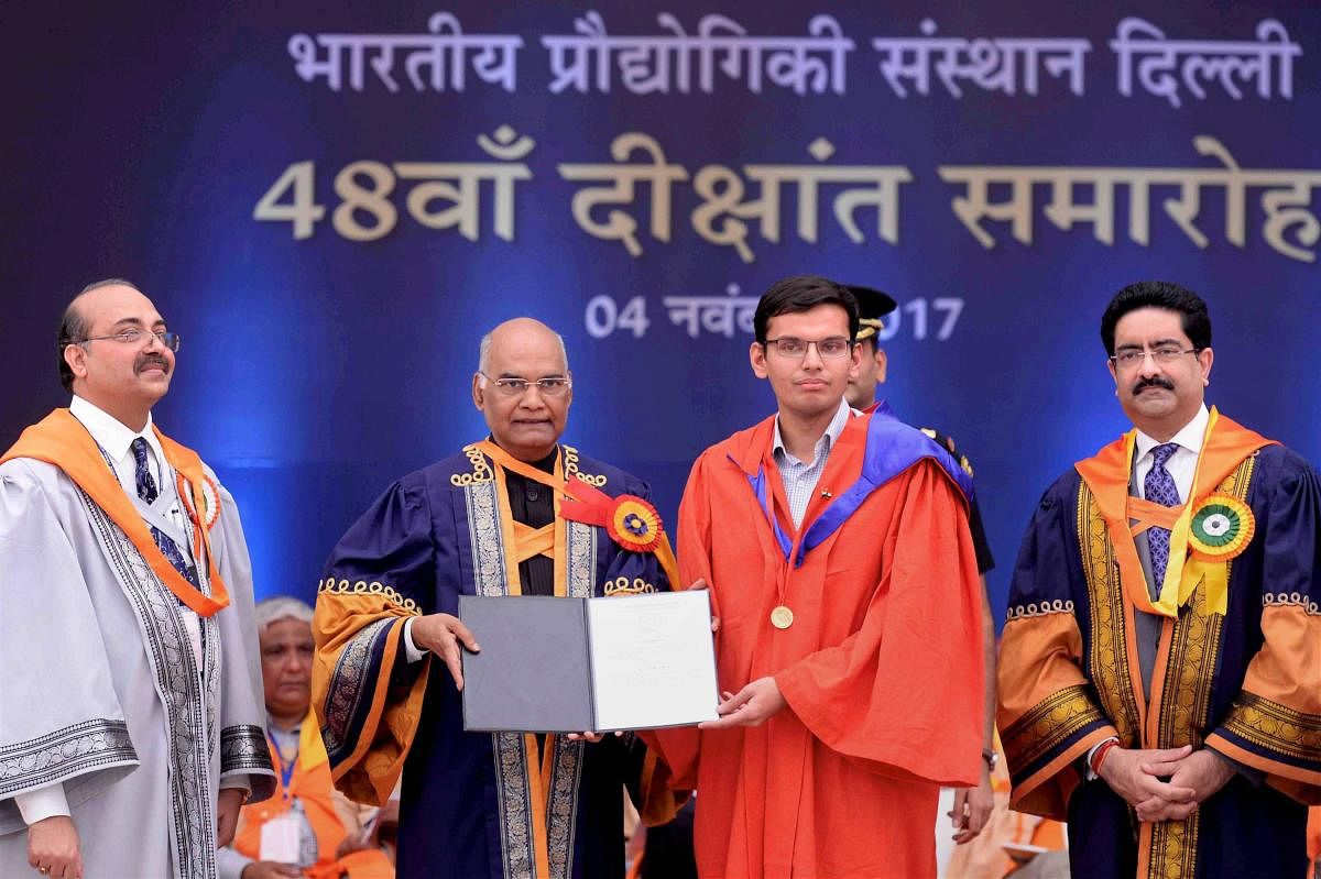 President Ram Nath Kovind presenting degree to a student during the annual convocation of Indian Institute of Technology (IIT) Delhi at the institute's Hauz Khas campus in New Delhi on Saturday. Industrialist Kumar Mangalam Birla, chairman BOG, IIT- Delhi is also seen. Photo / RB