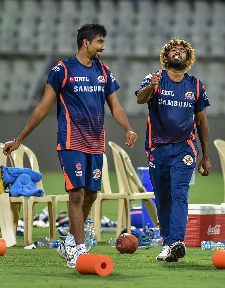 (Left) Chennai Super Kings' Dwayne Bravo makes a point to MS Dhoni during a practice session in Mumbai. Mumbai paceman Jasprit Bumrah and their bowling mentor Lasith Malinga share a light moment. PTI