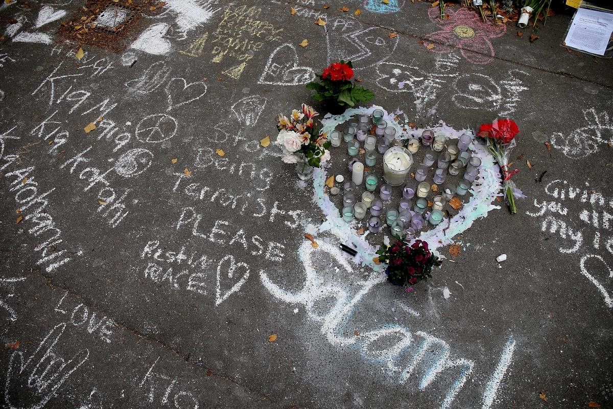 Messages written in chalk are seen on a pavement in Christchurch after 50 worshippers were killed last week in two mosque attacks. (AFP Photo)