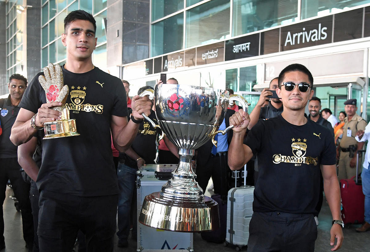 GLITTERING HAUL: BFC captain Sunil Chhetri and goalkeeper Gurpreet Singh, the Golden Glove winner, arrive with the ISL Trophy at the Kempegowda International Airport on Monday. DH Photo/ Srikanta Sharma R