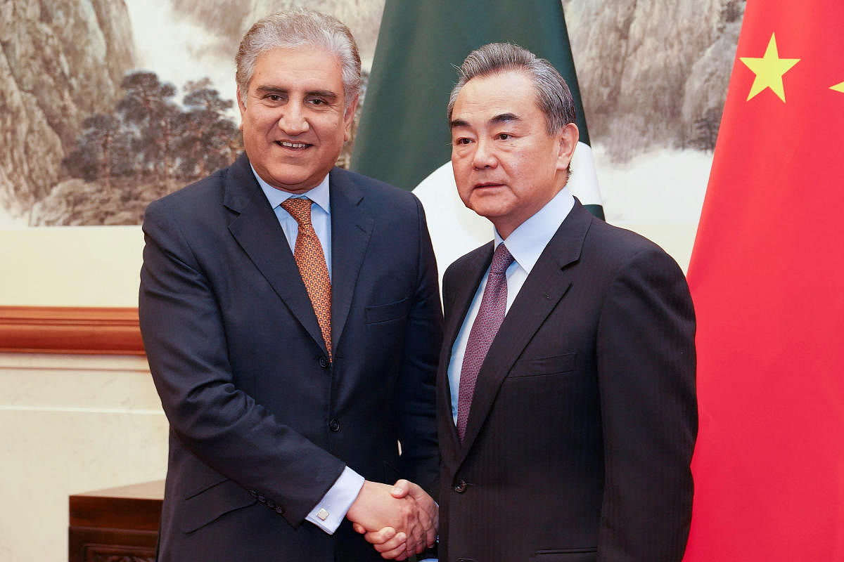 Chinese Foreign Minister Wang Yi shakes hands with Pakistani Foreign Minister Shah Mehmood Qureshi during a meeting at Diaoyutai State Guesthouse in Beijing, China. Reuters photo