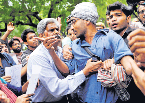 DCP S B S Tyagi detains AISA activists who were protesting against Delhi University's four-year  undergraduate programme outside Parliament Street police station in New Delhi on Thursday. PTI photo