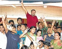 Success saga: Super-30 founder Anand Kumar flashes the victory sign along with his students, who passed the prestigious joint entrance examination  for the IIT with flying colours, in Patna on Wednesday.  MOHAN PRASAD