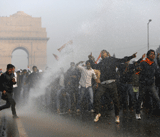 Indian demonstrators charge the riot police line as authorities unleash water cannon during a protest calling for better safety for women following the rape of a student last week, in front the India Gate monument in New Delhi on December 23, 2012. In the biggest protest so far, several thousand college students rallied at the India Gate monument in the heart of the capital where they were baton-charged, water cannoned and tear gassed by the police. AFP PHOTO
