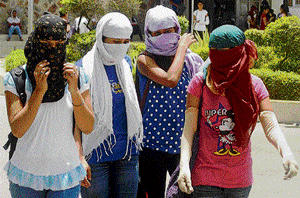 College girls cover their faces to get respite from scorching heat as temperature soars in Gurgaon on Monday. PTI