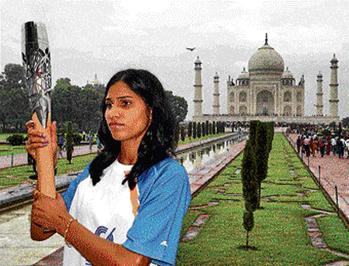 Steeplechaser Sudha Singh holds the Queen's Baton in front of the Taj Mahal on Saturday. PTI