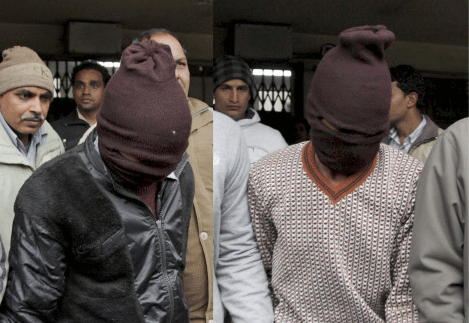 Police officials escort two of the accused in the gang rape of a 51-year-old Danish tourist as they walk out of court in New Delhi. PTI photo