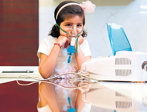 Amanat Devi Jain, 4, who her father says breathes normally outside of India, receives one of her twice-daily breathing treatments for her asthma in New Delhi. NYT