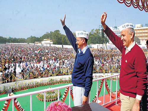 back to future: Delhi Chief Minister Arvind Kejriwal and deputy CM Manish Sisodia wave at supporters during the swearing-in ceremony at Ramlila maidan in New Delhi on Saturday. PTI