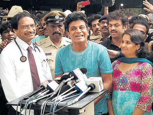 Actor Shivarajkumar, who was discharged from hospital on Thursday, addresses media in Bengaluru. His wife, Geetha Shivarajkumar is also seen. DH PHOTO