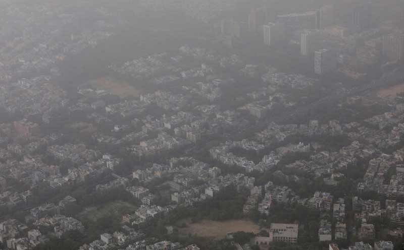 Buildings are seen blanketed by haze and dust on the outskirts of New Delhi, India, June 14, 2018. REUTERS