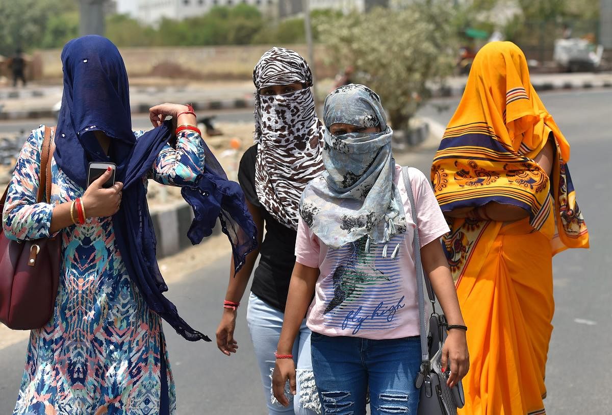 Women cover their faces with scarves to protect themselves from heat in New Delhi. PTI File Photo