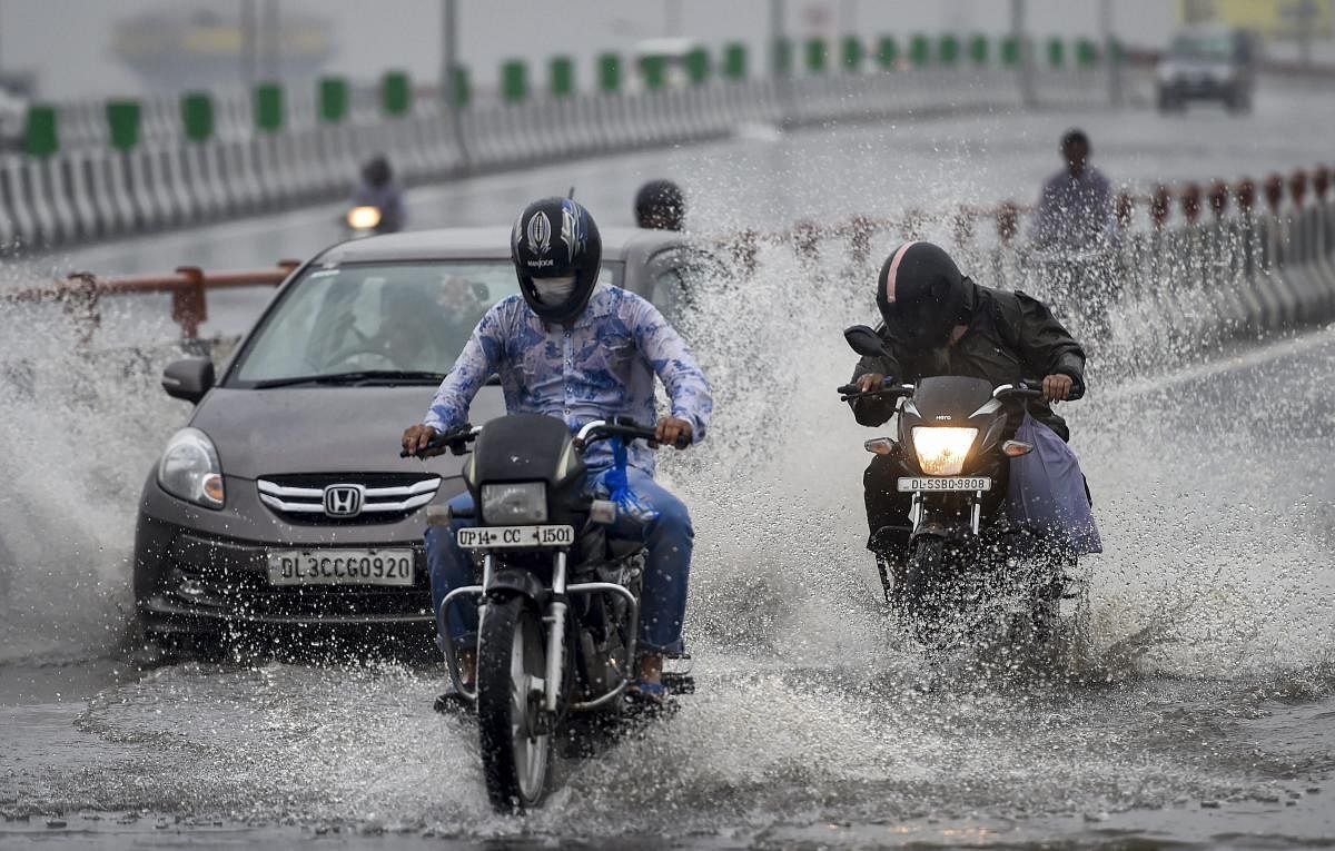 Vehicles wade through waterlogged road on NH-24 during rainfall, in New Delhi. (PTI Photo)