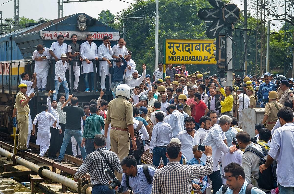 Congress Party supporters stop a train during 'Bharat Bandh' protest called by Congress and other parties against fuel price hike and depreciation of the rupee, in Moradabad, Monday, Sept 10, 2018. (PTI Photo)