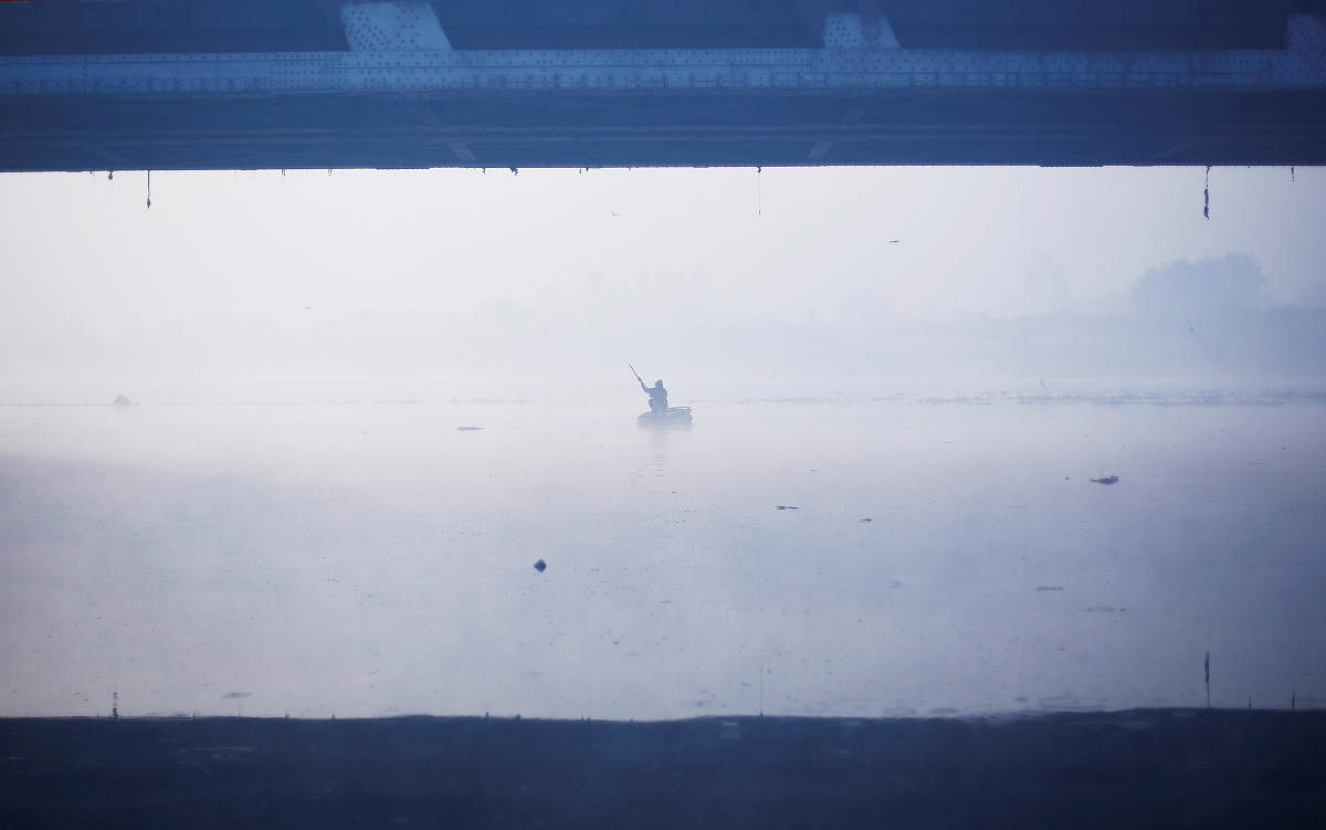 A man paddles a handmade boat across the Yamuna river on a foggy winter morning in New Delhi, India December 27, 2018. (REUTERS)