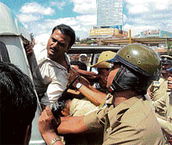 A KSRTC employee who verbally abused a lady conductor at the new bus stand in Kolar on Thursday is pushed into a police jeep. dh photoA KSRTC employee who verbally abused a lady conductor at the new bus stand in Kolar on Thursday is pushed into a police jeep. dh photo