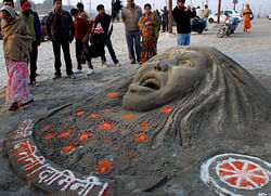 Sand artists made a sand sculpture of gang rape victim girl to pay tribute at the bank of river Ganges at Sangam in Allahabad on Tuesday. PTI