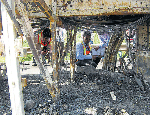 aftermath: Experts from the NATRiP team examine the burnt bus at the accident spot near Haveri on Friday. dh Photo