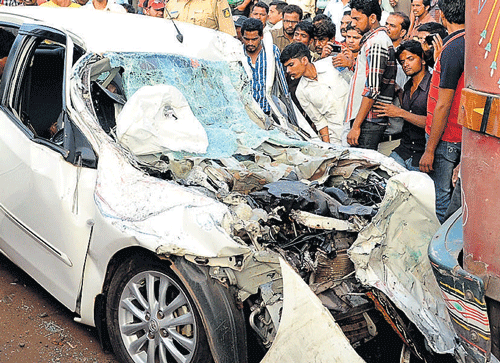 The mangled remains of the car that rammed a stationary lorry on National Highway 4 near Mahanteshnagar in  Belgaum on Monday. DH Photo