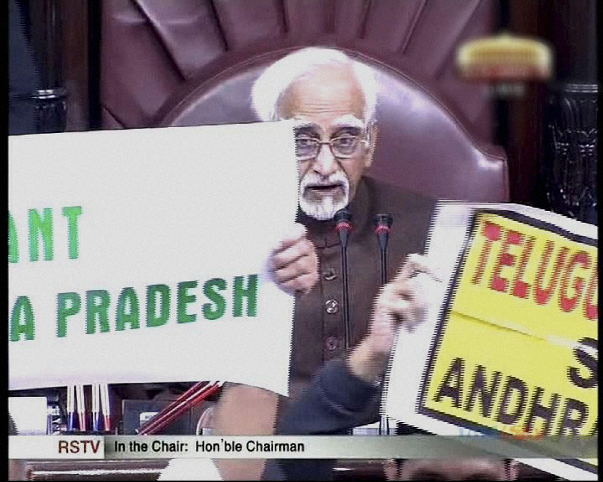 Members protest to disrupt Prime Minister Manmohan Singh's speech during the debate on Andhra Pradesh Reorganisation Bill, 2014 in Rajya Sabha in New Delhi on Thursday. PTI Photo/ TV GRAB