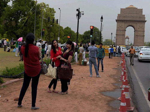 People enjoy the cool weather near  India Gate after shower in New Delhi on Friday. PTI
