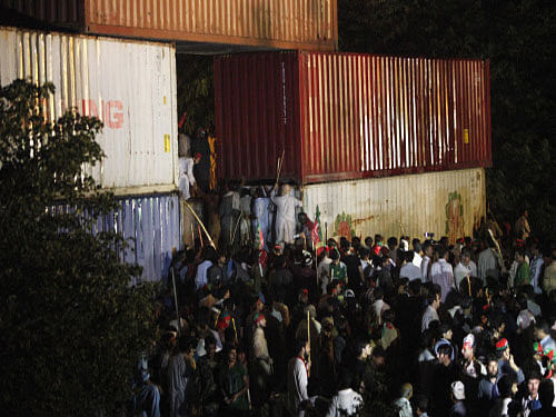 Supporters of former international cricketer Imran Khan, chairman of the Pakistan Tehreek-e-Insaf (PTI) political party, climb on container barricades as they participate during a Freedom March to the parliament house in Islamabad. Reuters photo