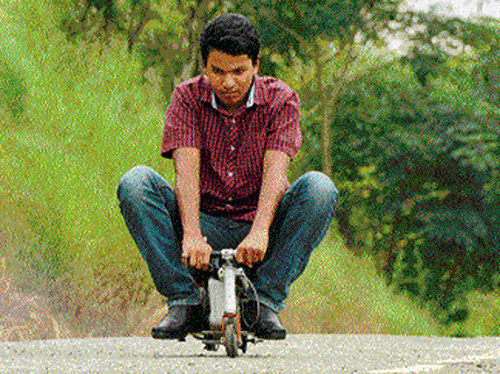 Dharwad lad R Girish rides the tiny bike he has designed.  DH Photo