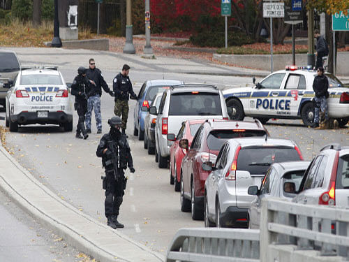 Police search cars and pedestrians as they leave the Alexandra Bridge and enter Gatineau, Quebec near the Parliament Buildings in Ottawa. Security has been stepped up at parliaments and Canadian diplomatic missions around Australia, a day after a gunman opened fire at parliament in that country killing one soldier, according to a media report. AP photo